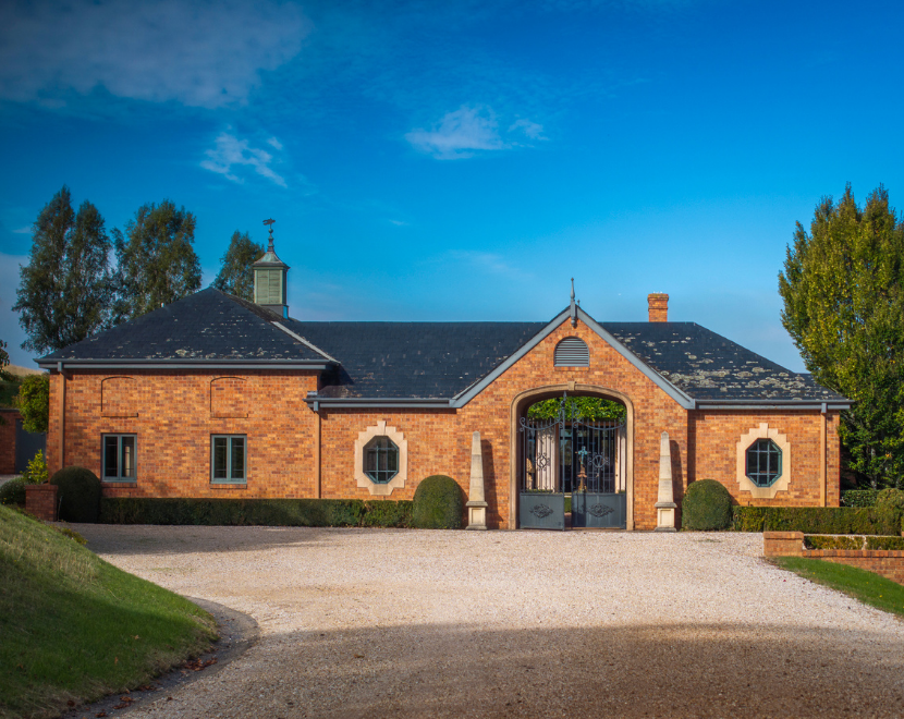 Beautiful brick estate with gated entrance and lush landscaping.